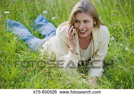 woman using cell phone in meadow View Large Photo Image Stock Photograph - woman using cell phone in meadow. Fotosearch