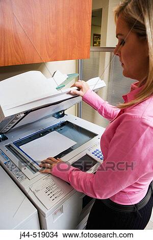 Picture - Woman using copy machine in office. Fotosearch