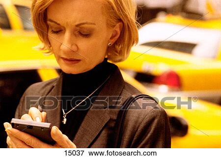 Stock Photo - Woman using electronic organizer. Fotosearch