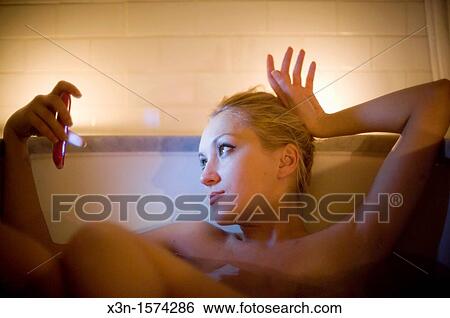 Woman using iPhone in bathtub View Large Photo Image Stock Photograph - Woman using iPhone in bathtub. Fotosearch