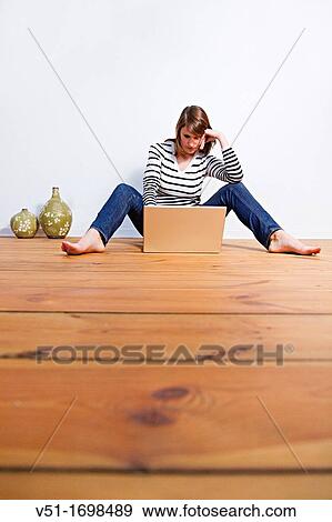 Woman using laptop at home View Large Photo Image Stock Photo - Woman using laptop at home. Fotosearch