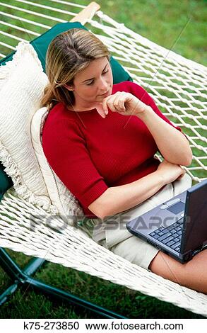 Woman using laptop in hammock View Large Photo Image Stock Image - Woman using laptop in hammock. Fotosearch