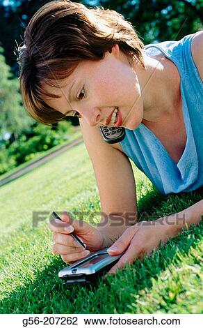 Stock Image - Woman using pocket organizer. Fotosearch