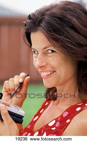 Woman using pocket personal computer View Large Photo Image Stock Photograph - Woman using pocket personal computer. Fotosearch