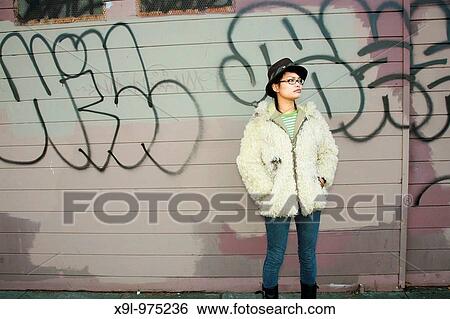 Stock Photograph - Woman waiting for the bus to come in a bad neighborhood.. Fotosearch