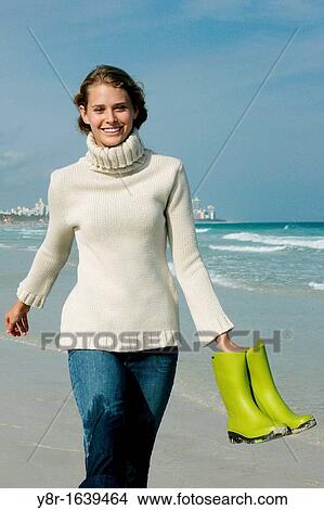 Picture - woman walcking next to seaside. Fotosearch