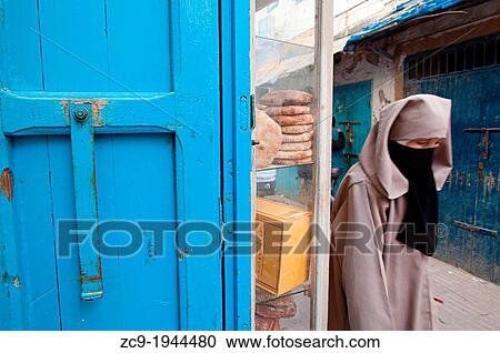 Woman walking by the streets of Essaouira medina, Morocco. View Large Photo Image Stock Image - Woman walking by the streets of Essaouira medina, Morocco.. Fotosearch