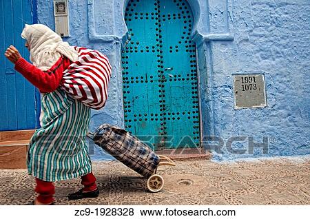 Woman walking by the streets of the blue medina Chefchaouen, Rif region, Morocco View Large Photo Image Stock Photo - Woman walking by the streets of the blue medina Chefchaouen, Rif region, Morocco. Fotosearch