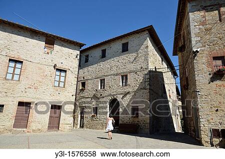 Woman walking by village place, San Gusme, Tuscany, Italy View Large Photo Image Stock Photo - Woman walking by village place, San Gusme, Tuscany, Italy. Fotosearch