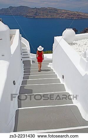 Woman walking down the steps in Oia town with Caldera at the background, Santorini, Cyclades Islands, Greek Islands, Greece, Europe. View Large Photo Image Stock Image - Woman walking down the steps in Oia town with Caldera at the background, Santorini, Cyclades Islands, Greek Islands, Greece, Europe.. Fotosearch