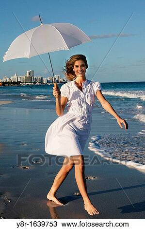 Stock Image - Woman walking next to seaside. Fotosearch