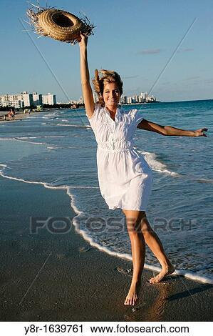 Woman walking next to seaside View Large Photo Image Stock Image - Woman walking next to seaside. Fotosearch