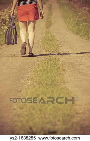 Woman walking on a dirt road View Large Photo Image Stock Photography - Woman walking on a dirt road. Fotosearch