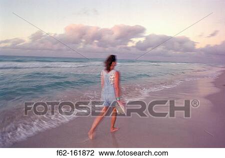 Woman walking on beach View Large Photo Image Stock Image - Woman walking on beach. Fotosearch