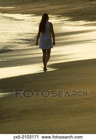 Woman walking on the beach at sunset. View Large Photo Image Stock Image - Woman walking on the beach at sunset.. Fotosearch