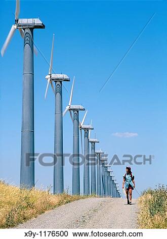 Woman walking on track beside wind turbines, part of the massive wind farm complex at Altamont near Livermore, California, USA View Large Photo Image Stock Image - Woman walking on track beside wind turbines, part of the massive wind farm complex at Altamont near Livermore, California, USA. Fotosearch