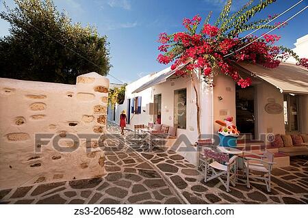 Stock Image - Woman walking through the alleys of Parikia, Paros, Cyclades Islands, Greek Islands, Greece, Europe.. Fotosearch