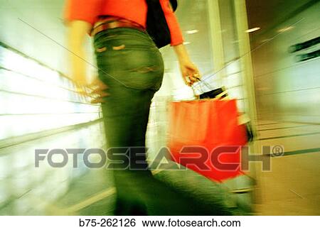 Woman walking throught a corridor View Large Photo Image Stock Photograph - Woman walking throught a corridor. Fotosearch