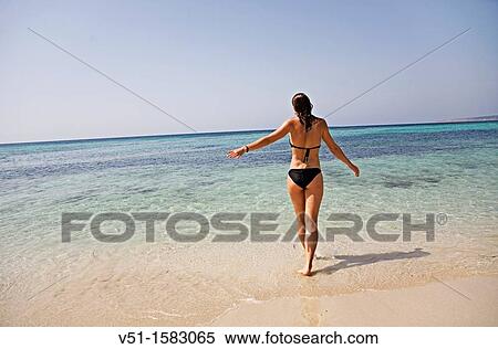 Woman walking to the water at the beach in Formentera, Balearic Islands, Spain View Large Photo Image Stock Photography - Woman walking to the water at the beach in Formentera, Balearic Islands, Spain. Fotosearch