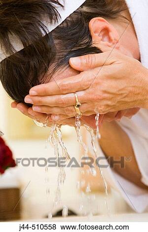 Woman washing face in the bathroom View Large Photo Image Stock Photo - Woman washing face in the bathroom. Fotosearch