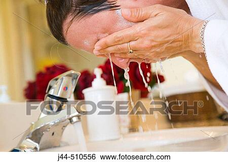 Woman washing face in the bathroom View Large Photo Image Stock Photograph - Woman washing face in the bathroom. Fotosearch