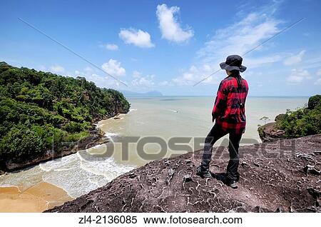 Woman watching the South China sea from a lookout on the Telok Pandan Kecil trail. Malaysia, Borneo, Sarawak, Bako National Park. Model Released. View Large Photo Image Stock Photography - Woman watching the South China sea from a lookout on the Telok Pandan Kecil trail. Malaysia, Borneo, Sarawak, Bako National Park. Model Released.. Fotosearch
