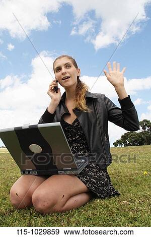 woman waving at a friend while using cell phone and laptop View Large Photo Image Stock Photo - woman waving at a friend while using cell phone and laptop. Fotosearch