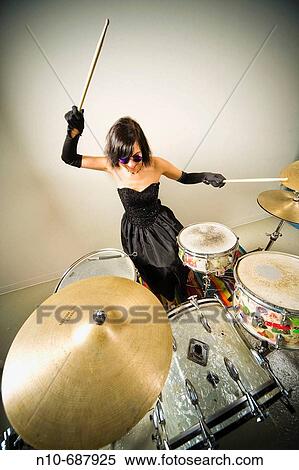 Woman, wearing an evening gown and blue sunglasses, playing the drums. View Large Photo Image Stock Photography - Woman, wearing an evening gown and blue sunglasses, playing the drums.. Fotosearch