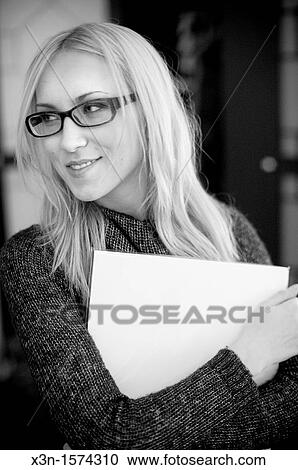 Stock Image - Woman wearing glasses holding papers. Fotosearch