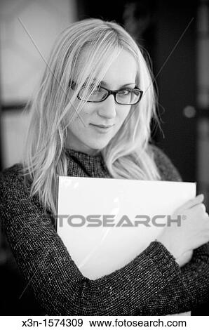 Stock Photo - Woman wearing glasses holding papers. Fotosearch
