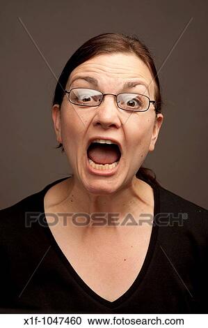 Woman wearing glasses shouting yelling screaming making loud noise View Large Photo Image Stock Image - Woman wearing glasses shouting yelling screaming making loud noise. Fotosearch