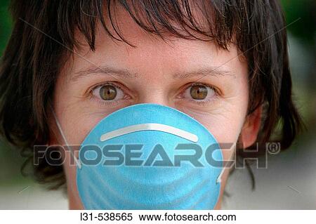 Woman wearing sanitary sterile mask for hygienic reasons over mouth and nose in the time of disease and germs and bugs and illness View Large Photo Image Stock Photography - Woman wearing sanitary sterile mask for hygienic reasons over mouth and nose in the time of disease and germs and bugs and illness. Fotosearch