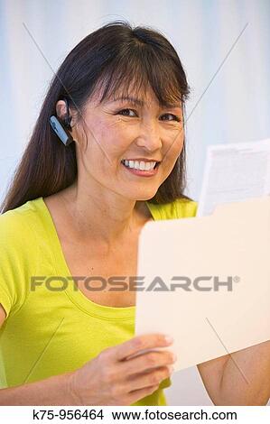 Woman wearing telephone earpiece View Large Photo Image Picture - Woman wearing telephone earpiece. Fotosearch