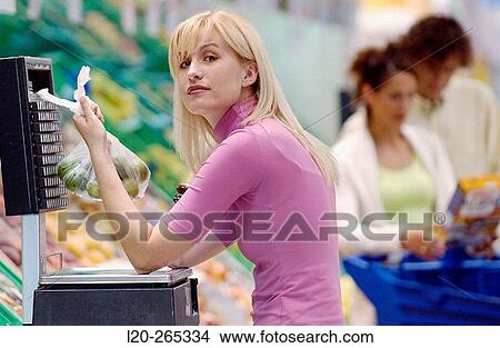 Woman weighing fruit at supermarket View Large Photo Image Picture - Woman weighing fruit at supermarket. Fotosearch