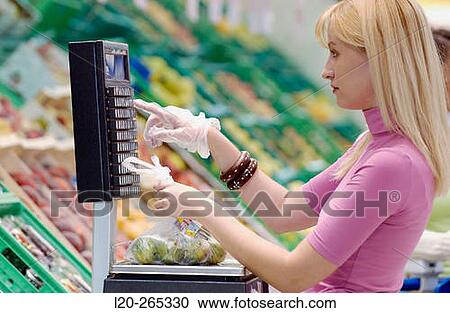 Woman weighing fruit at supermarket View Large Photo Image Stock Image - Woman weighing fruit at supermarket. Fotosearch