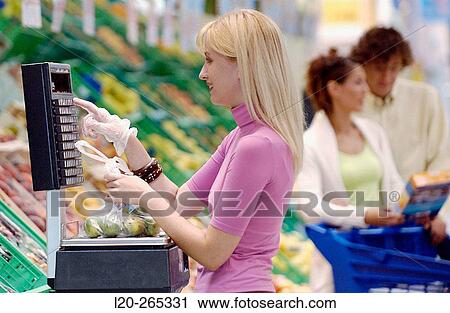 Woman weighing fruit at supermarket View Large Photo Image Stock Image - Woman weighing fruit at supermarket. Fotosearch