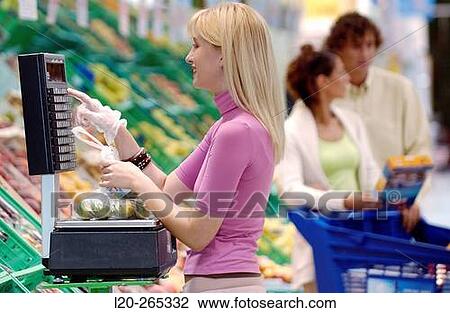 Woman weighing fruit at supermarket View Large Photo Image Stock Image - Woman weighing fruit at supermarket. Fotosearch