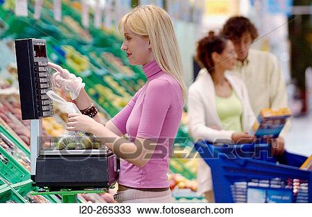 Woman weighing fruit at supermarket View Large Photo Image Stock Image - Woman weighing fruit at supermarket. Fotosearch