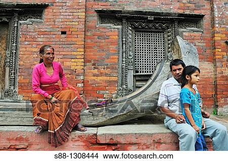 Picture - Woman who sells souvenir and daughtr and father at Durbar square sitting front of Kumari ghar where Kumari lives. Fotosearch