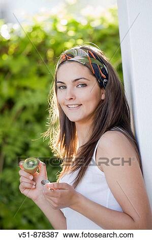 Woman wit a piece of fruit outdoor looking at camera View Large Photo Image Stock Photo - Woman wit a piece of fruit outdoor looking at camera. Fotosearch