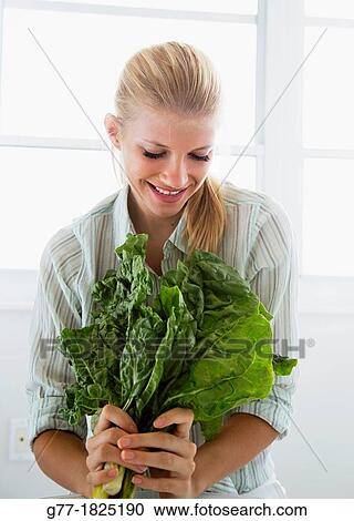 Stock Image - Woman with a green leaf. Fotosearch