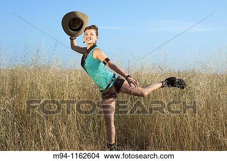 Picture - woman with a hat in her hand, smiling. Fotosearch
