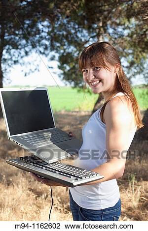 woman with a laptop and a computer keyboard in her hands View Large Photo Image Stock Image - woman with a laptop and a computer keyboard in her hands. Fotosearch
