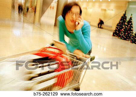 Woman with a shopping cart View Large Photo Image Stock Photo - Woman with a shopping cart. Fotosearch