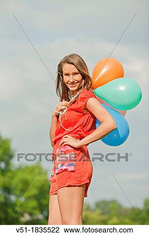Woman with air balloons in park View Large Photo Image Stock Image - Woman with air balloons in park. Fotosearch