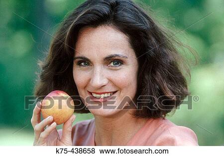 Stock Photo - Woman with an apple in her hand. Fotosearch