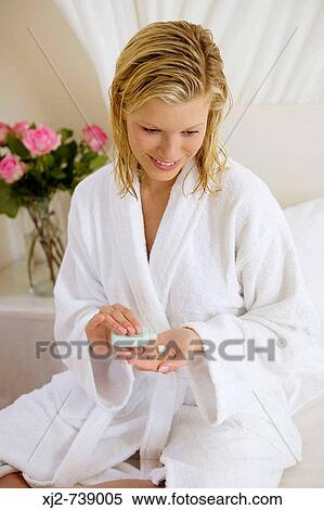 Woman with bathrobe applying lotion View Large Photo Image Stock Photography - Woman with bathrobe applying lotion. Fotosearch