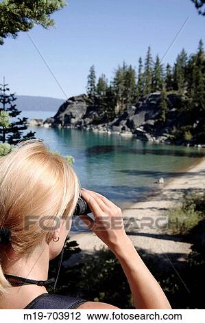 Woman with binoculars viewing a lake View Large Photo Image Stock Image - Woman with binoculars viewing a lake. Fotosearch