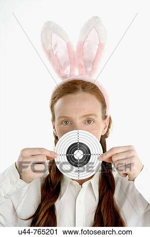 Stock Image - Woman with bunny ears holding target. Fotosearch