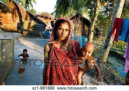 Stock Photo - Woman with child in Joy Mun Gol village on the Bangara River, Ganges Delta, Sundarbans, Bangladesh. Fotosearch